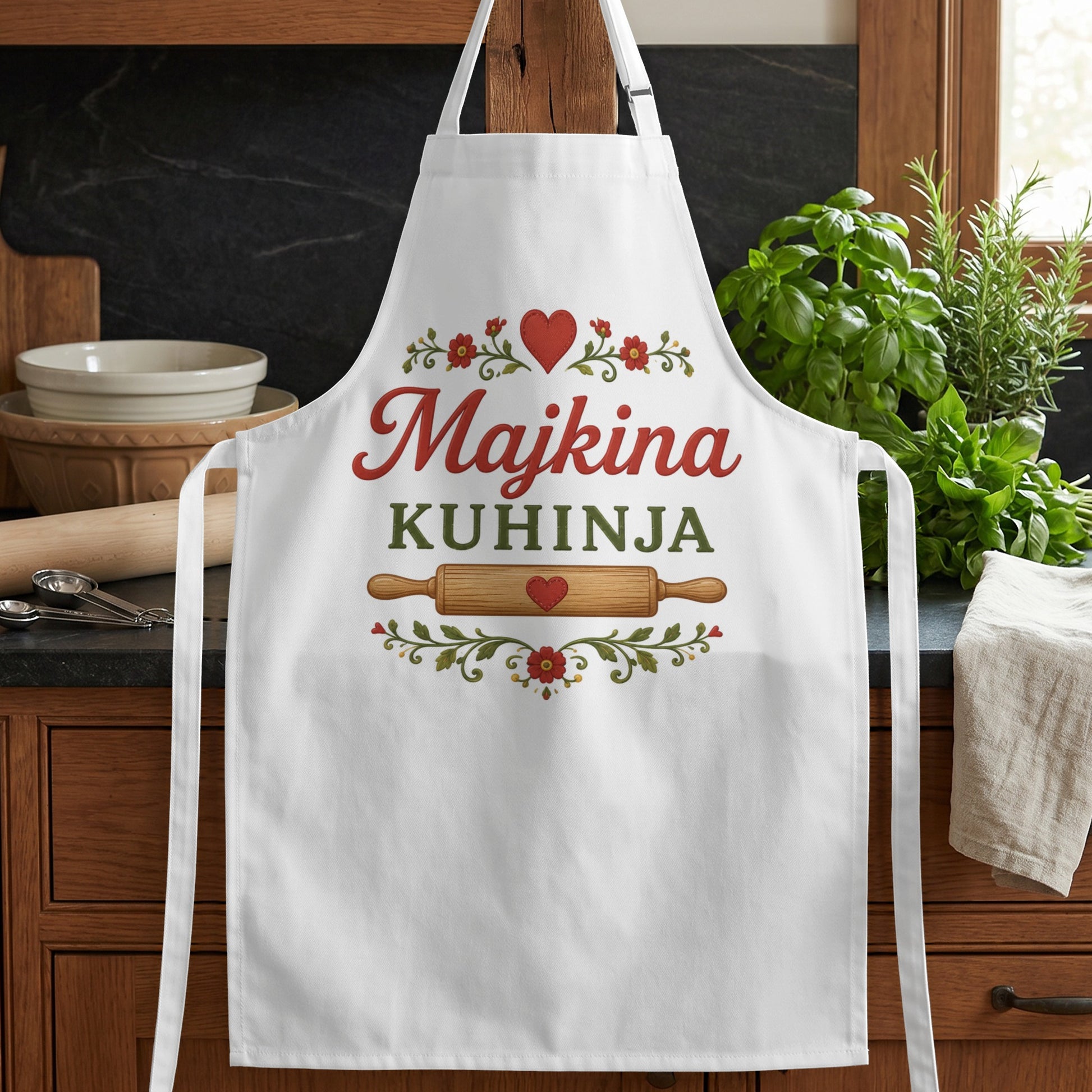 White apron with "Majkina KUHINJA" text, heart, rolling pin, and floral design.
