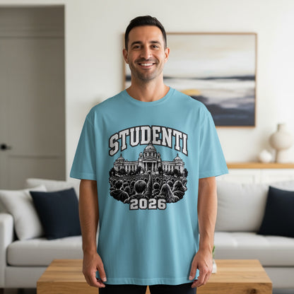 A smiling man wearing a light blue t-shirt with a graphic of a crowd and building.