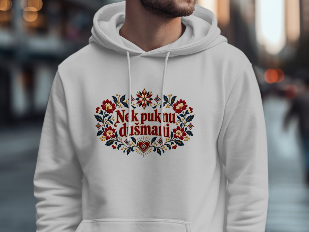 A man wearing a white hoodie with red floral embroidery and the text Nek puknu dusmani.
