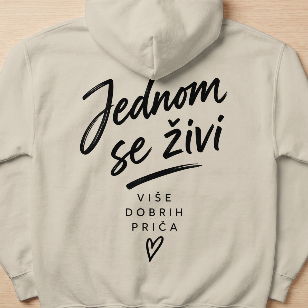Light beige hoodie with black text "Jednom se živi" and "Više dobrih priča".