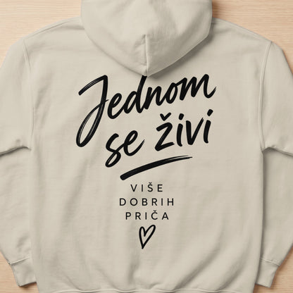 Light beige hoodie with black text "Jednom se živi" and "Više dobrih priča".