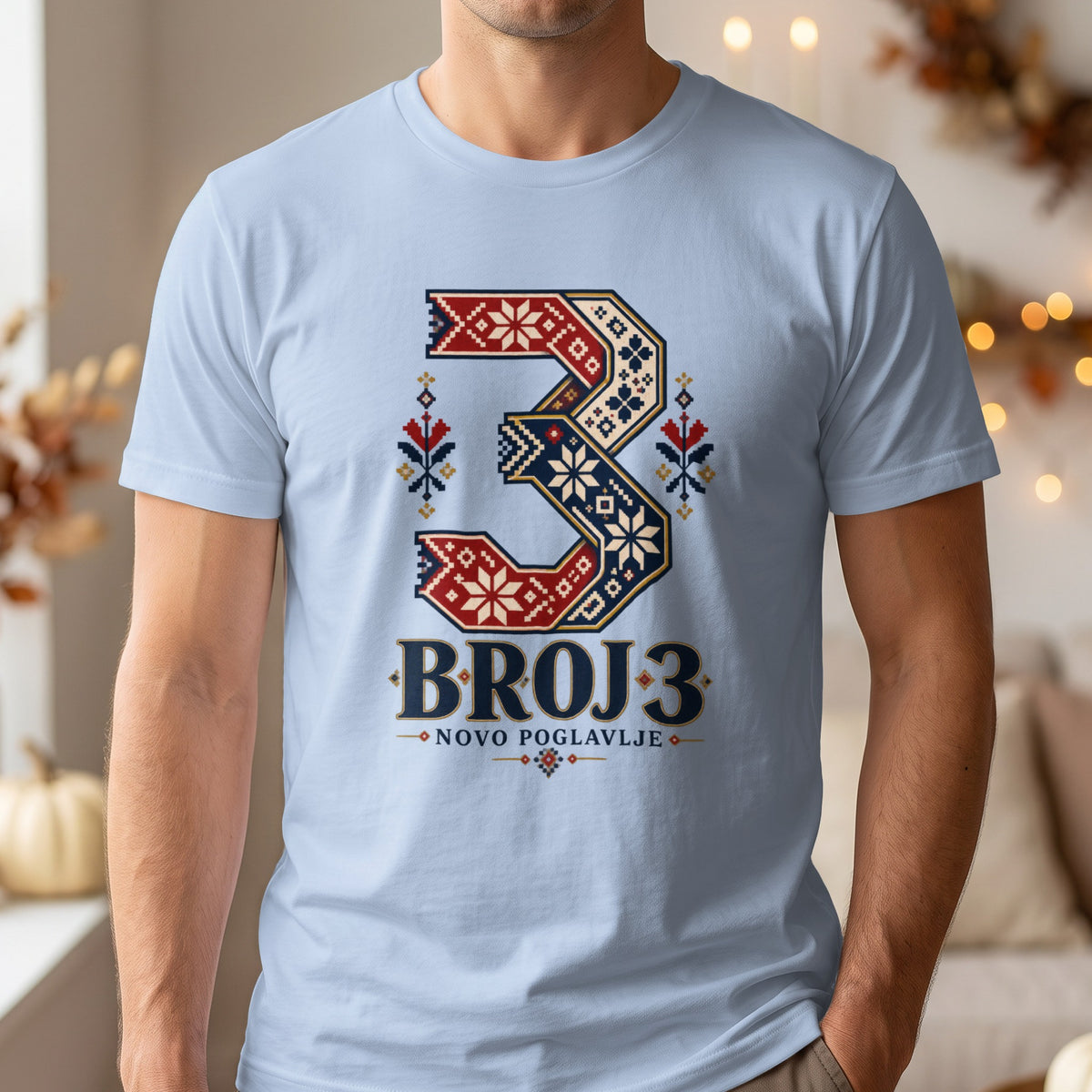 A person wearing a light blue t-shirt printed with a large number three and Serbian text.