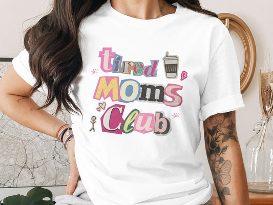 White t-shirt with "Tired Moms Club" text and fun graphics.