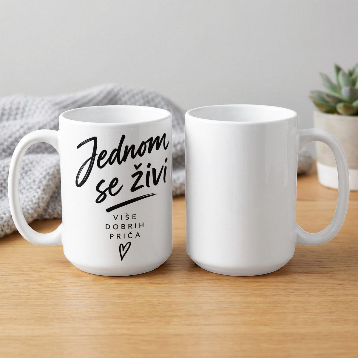 White mug with black text "Jednom se živi više dobrih priča" and a heart.