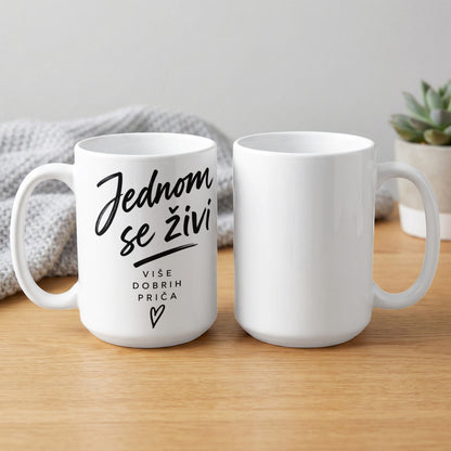 White mug with black text "Jednom se živi više dobrih priča" and a heart.