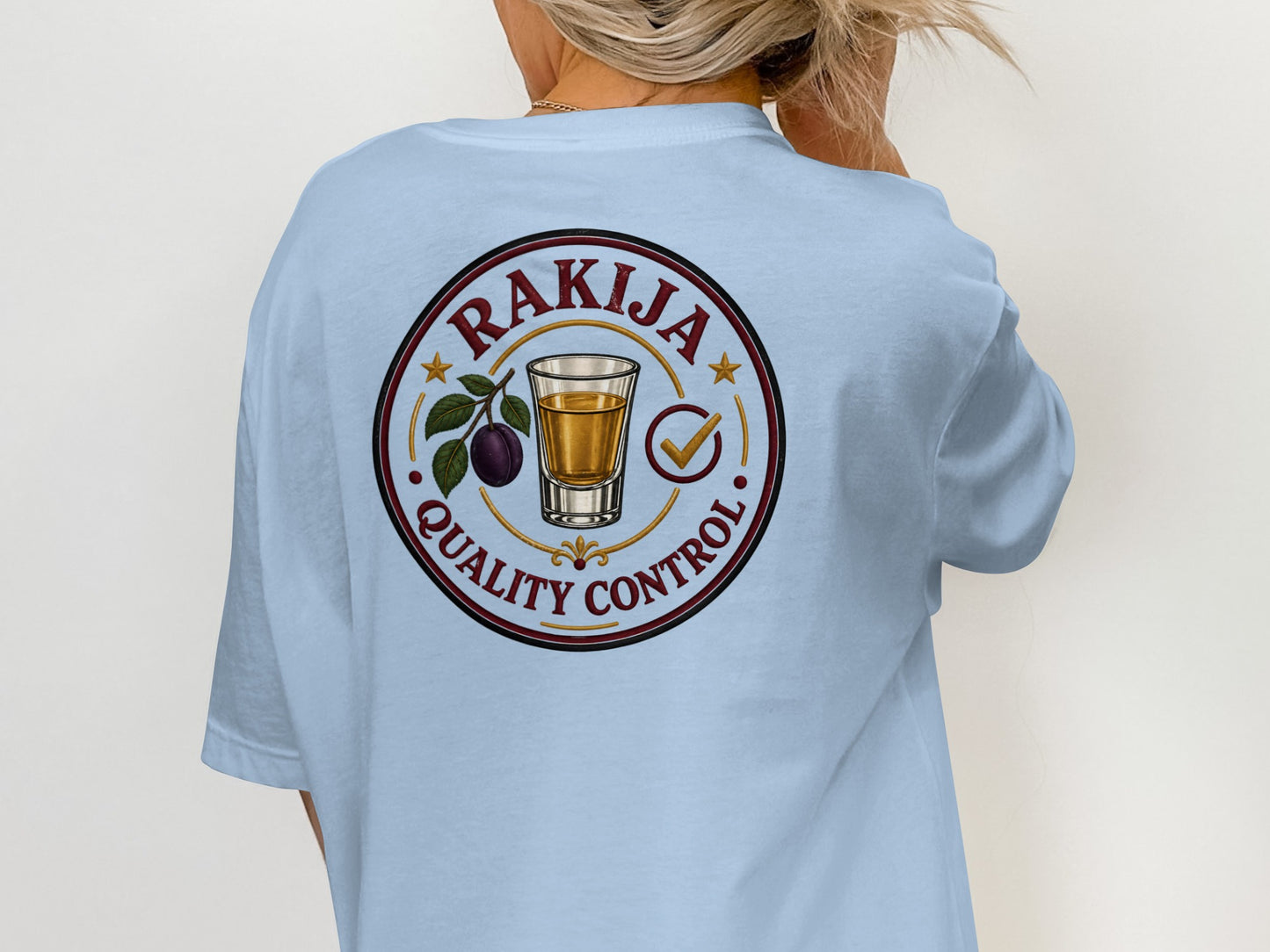 Light blue t-shirt with circular "Rakija Quality Control" logo featuring plum brandy shot.