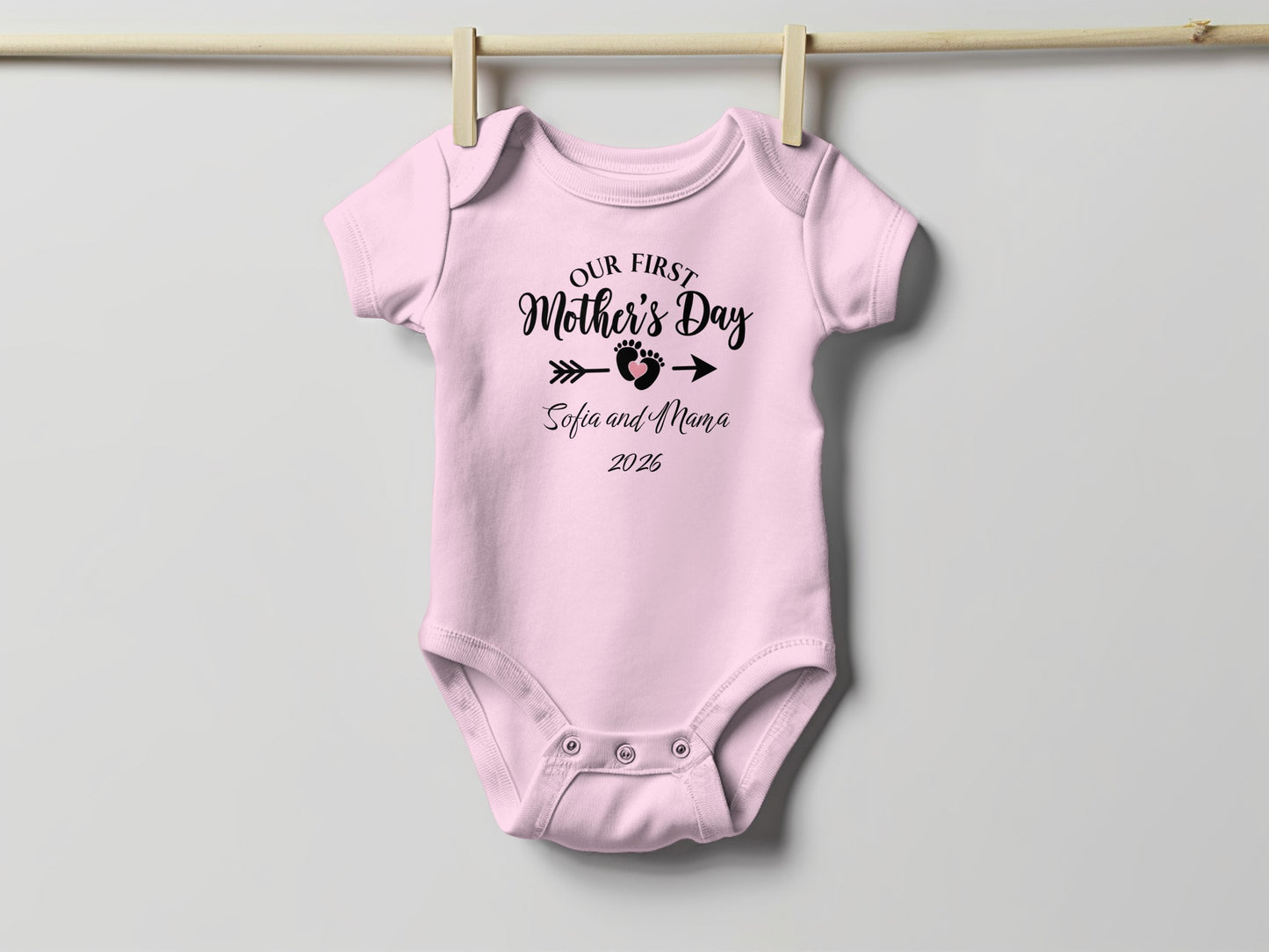 Pink baby onesie with "Our First Mother's Day Sofia and Mama 2026" text.