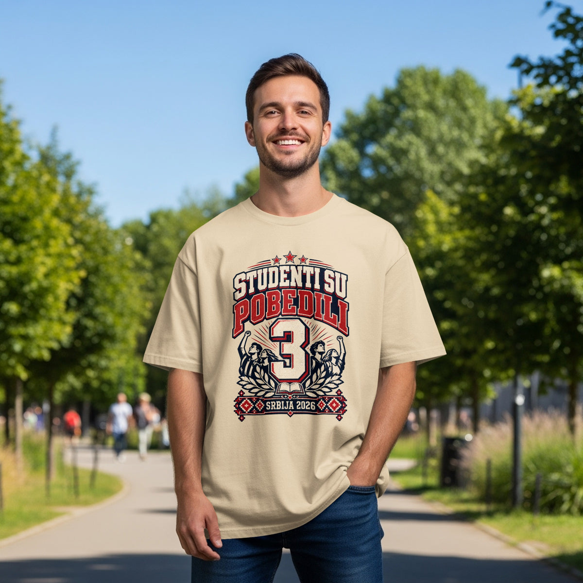 A smiling man wearing a beige t-shirt with a red, white, and blue graphic design containing the text "STUDENTI SU POBEDILI 3 SRBIJA 2026".