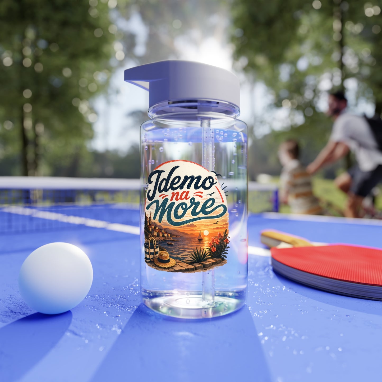 Clear bottle with "Idemo na More" label, beside a ping pong ball and paddle.
