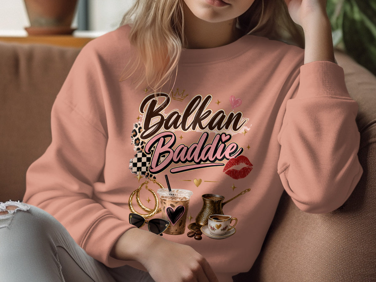 Pink sweatshirt with "Balkan Baddie" text, coffee, sunglasses, and jewelry graphic.