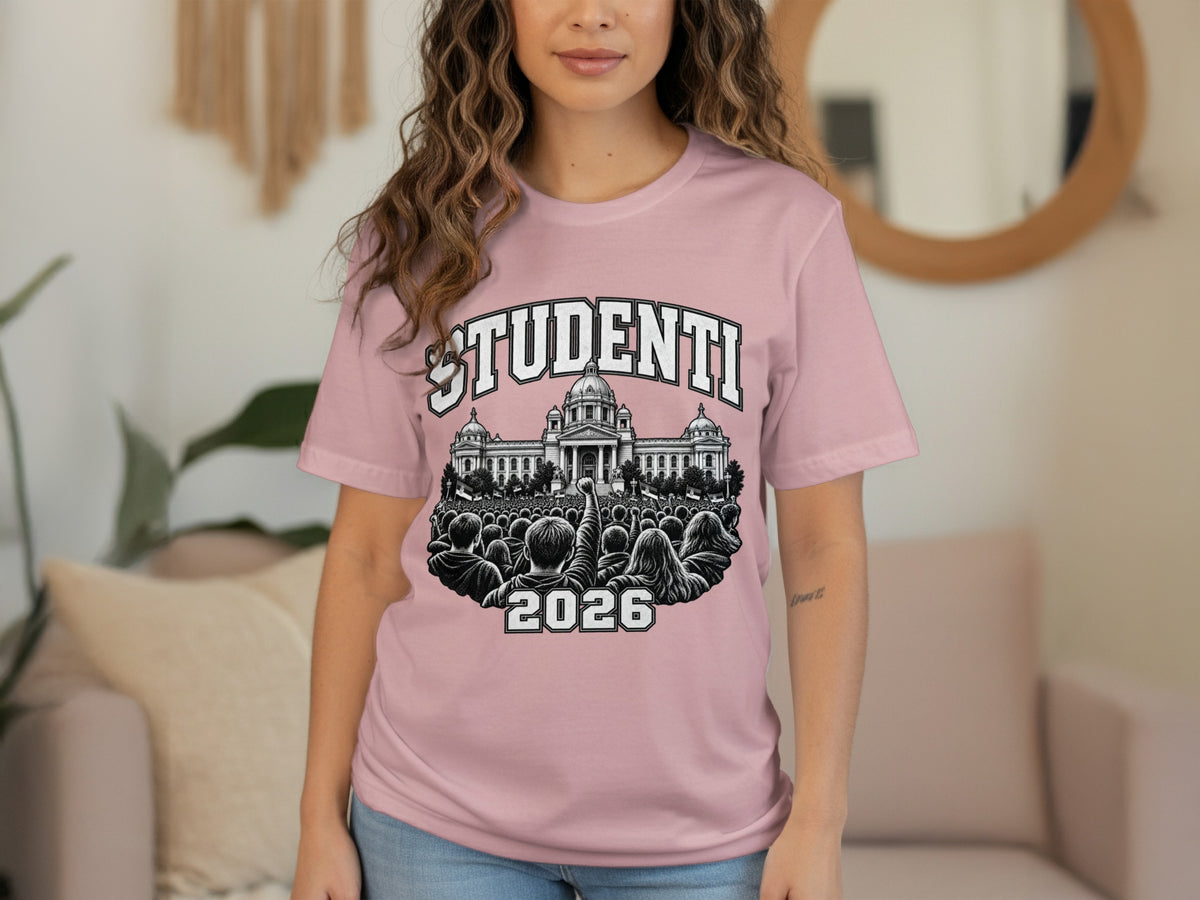 A woman wearing a pink t-shirt with a graphic of a crowd, a building, and the text "STUDENTI 2026."
